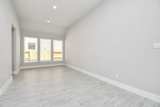 spare room with baseboards, recessed lighting, light wood-style floors, and vaulted ceiling