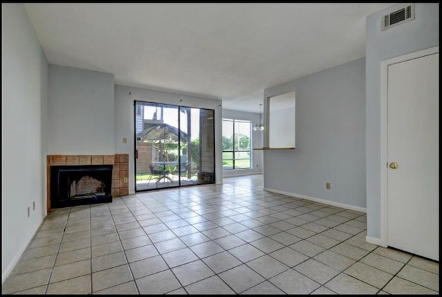 unfurnished living room featuring a tiled fireplace and light tile patterned floors