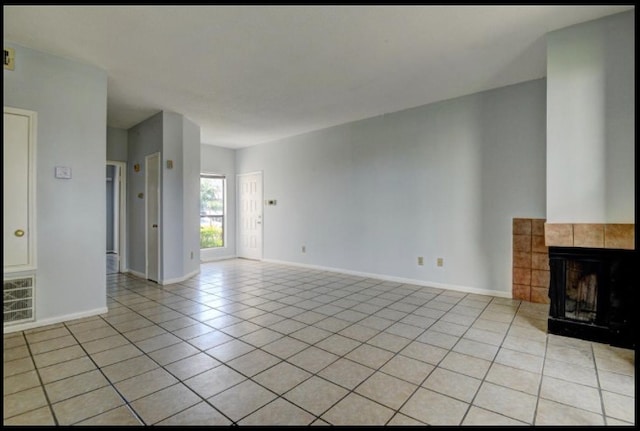 unfurnished living room featuring light tile patterned floors and a tile fireplace