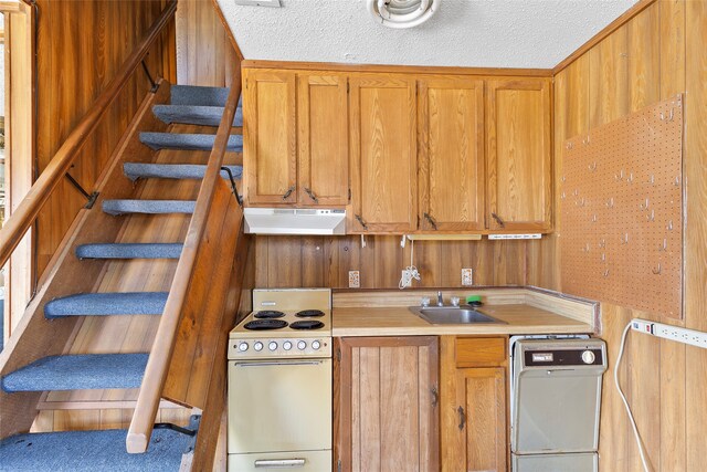 kitchen with white range, sink, a textured ceiling, and washer / clothes dryer