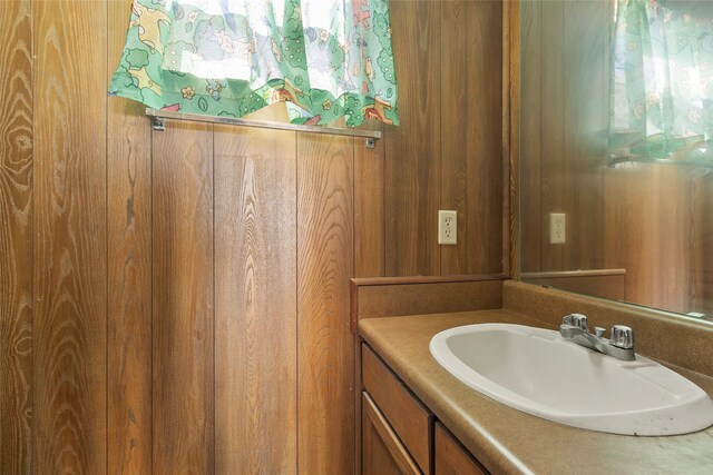 bathroom with vanity and wood walls