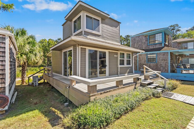 rear view of property with a wooden deck and a yard