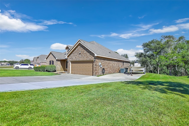 view of side of property with a lawn, central AC unit, and a garage