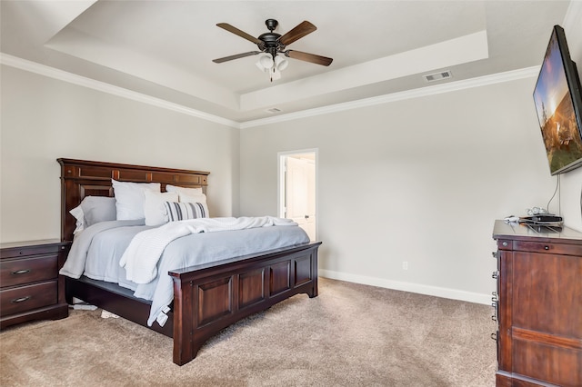 carpeted bedroom with ceiling fan, crown molding, and a tray ceiling