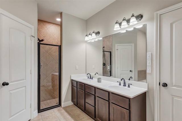 bathroom with vanity, a tile shower, and tile patterned floors