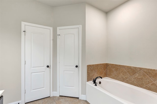 bathroom featuring vanity, a tub to relax in, and tile patterned flooring