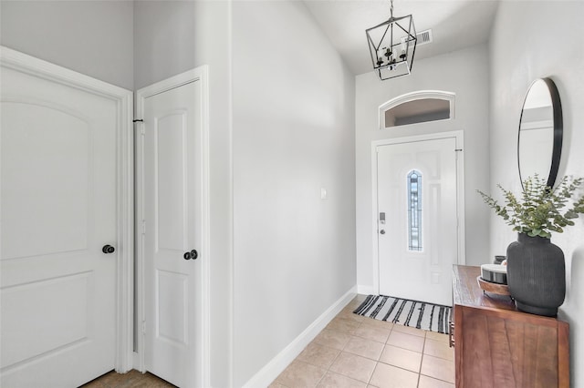 entryway with a notable chandelier and light tile patterned floors