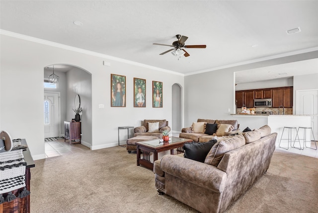 living room with ornamental molding, sink, light carpet, and ceiling fan