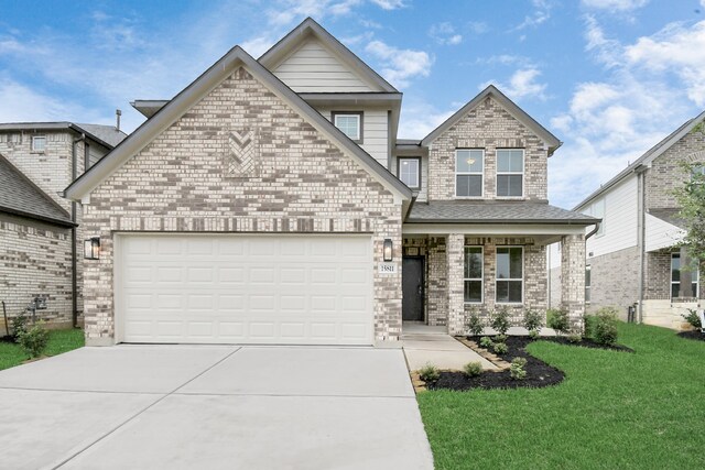 view of front of home with a front yard, a garage, and covered porch