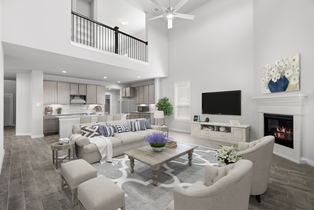 living room featuring a towering ceiling, dark wood-type flooring, and ceiling fan