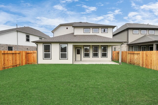 back of house with a patio area and a yard