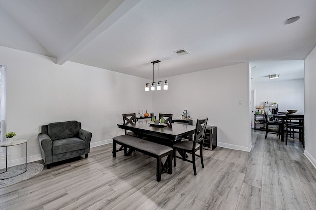 dining space with lofted ceiling and light hardwood / wood-style flooring