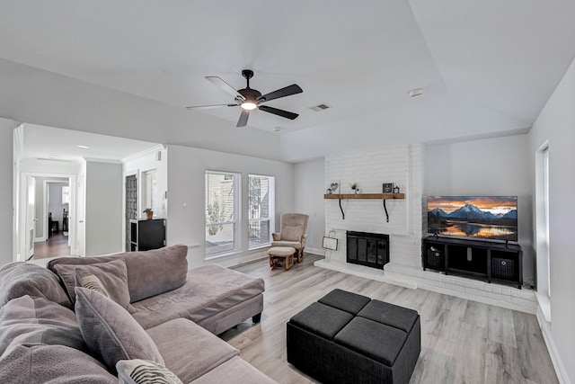 living room with ceiling fan, lofted ceiling, light hardwood / wood-style flooring, and a fireplace