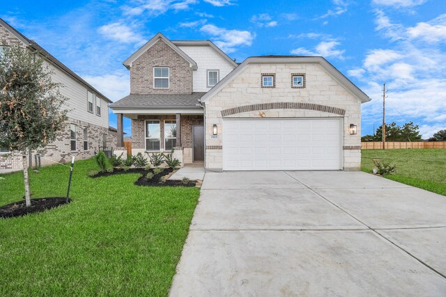 view of front of home featuring a porch, a front yard, and a garage