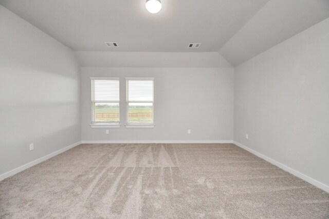 empty room featuring carpet flooring and lofted ceiling