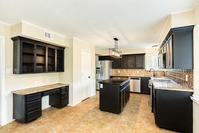 kitchen featuring crown molding, a kitchen island, appliances with stainless steel finishes, and decorative light fixtures