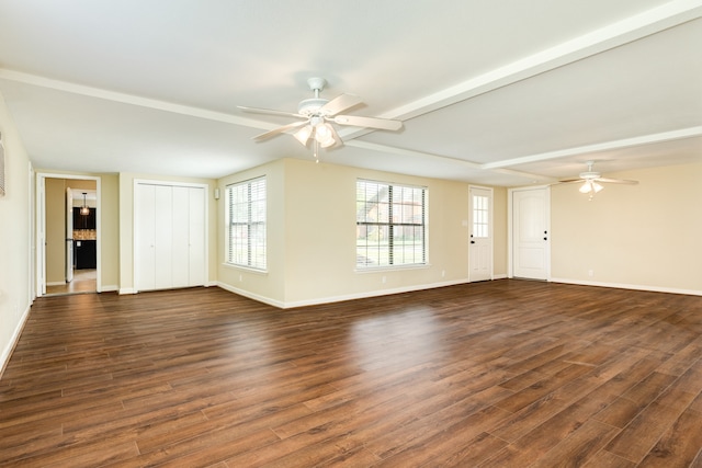 unfurnished living room featuring dark wood-type flooring, ceiling fan, and beamed ceiling