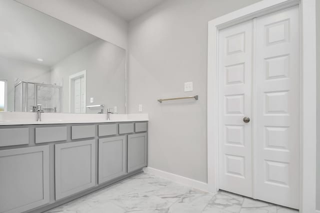 full bath featuring double vanity, a stall shower, and marble finish floor