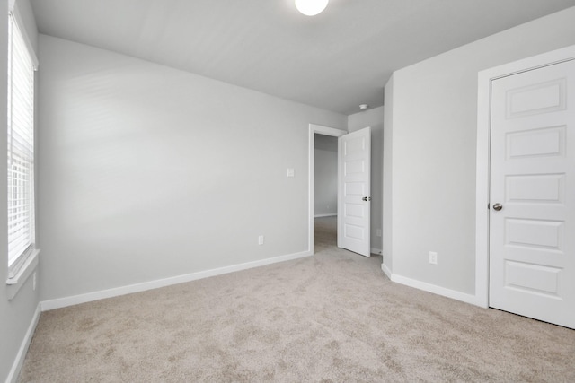 unfurnished bedroom featuring carpet flooring and baseboards