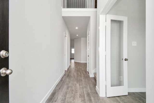 hallway with recessed lighting, wood finished floors, and baseboards