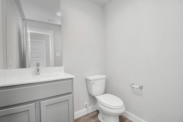 bathroom featuring vanity, hardwood / wood-style flooring, and toilet