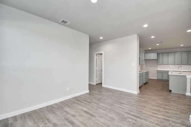 unfurnished living room featuring baseboards, recessed lighting, visible vents, and light wood-style floors