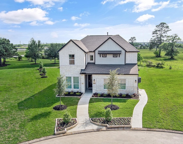 traditional-style home featuring roof with shingles, a front yard, and stone siding