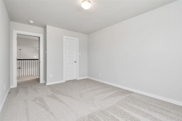 unfurnished bedroom featuring light carpet and a closet