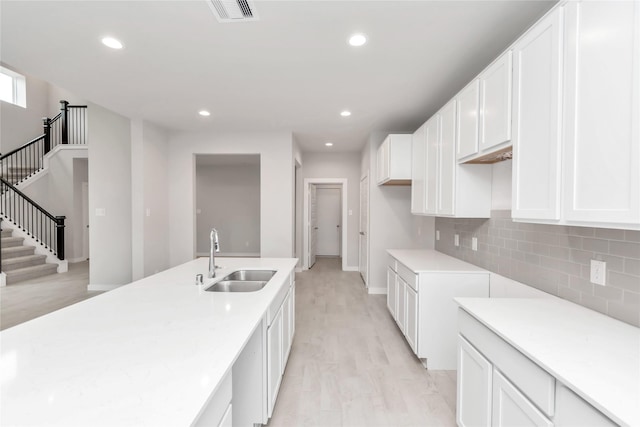 14707 Surfbird Ln, Houston, TX 77049 - kitchen featuring a sink, light wood finished floors, recessed lighting, backsplash, and white cabinetry