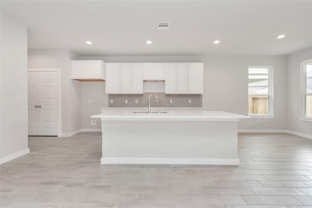 14707 Surfbird Ln, Houston, TX 77049 - kitchen with a sink, light countertops, an island with sink, white cabinets, and recessed lighting