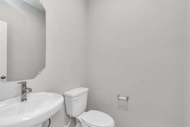 14707 Surfbird Ln, Houston, TX 77049 - half bathroom featuring a sink, toilet, and baseboards