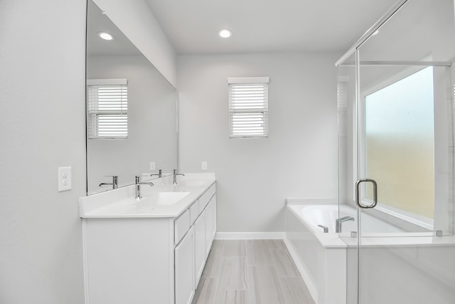 bathroom with vanity, shower with separate bathtub, and a healthy amount of sunlight