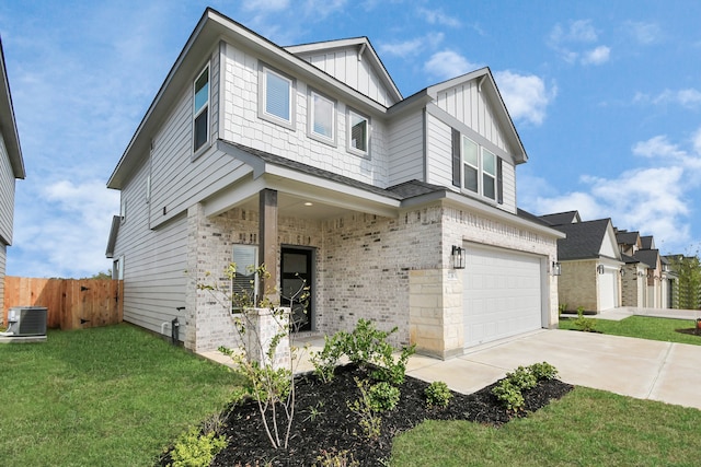 view of front of house with a front yard, central AC, and a garage