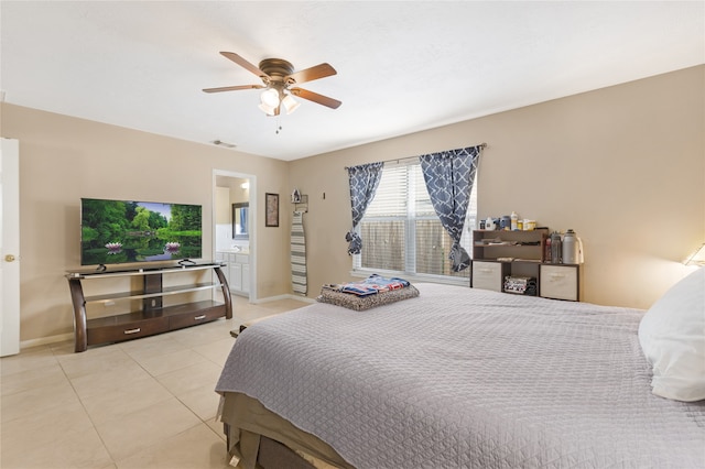 bedroom with ensuite bath, light tile patterned floors, and ceiling fan