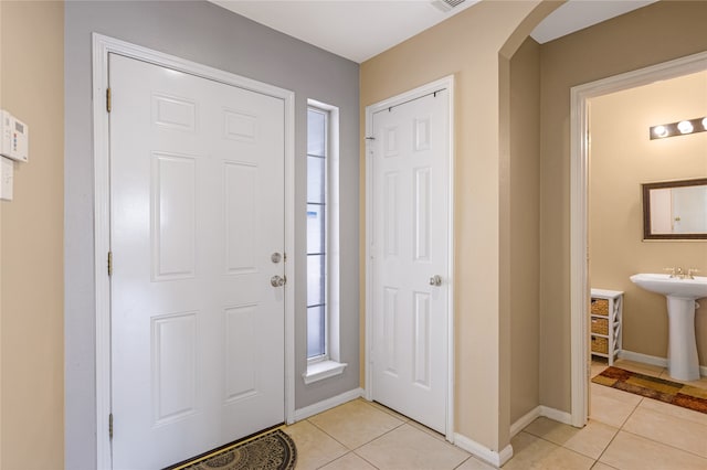 foyer entrance with sink and light tile patterned floors