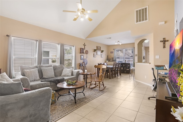 tiled living room featuring high vaulted ceiling and ceiling fan