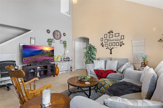 living room featuring a towering ceiling and light tile patterned floors