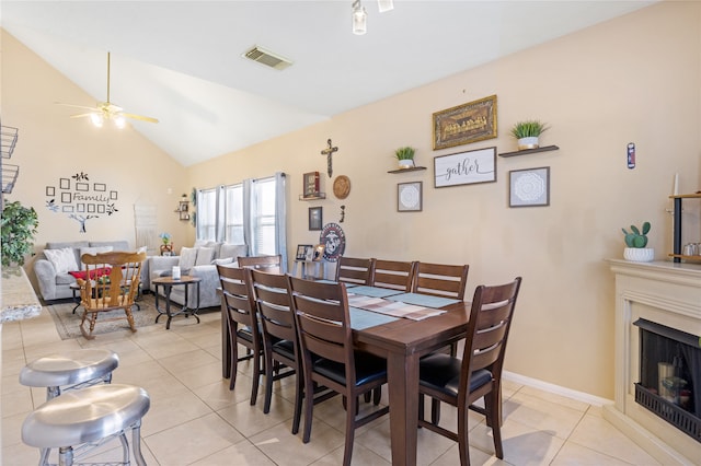 tiled dining area featuring ceiling fan and vaulted ceiling