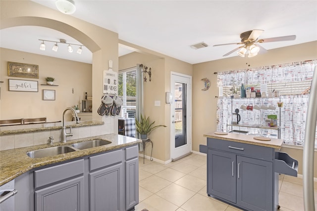 kitchen featuring dishwasher, sink, ceiling fan, gray cabinets, and light tile patterned floors