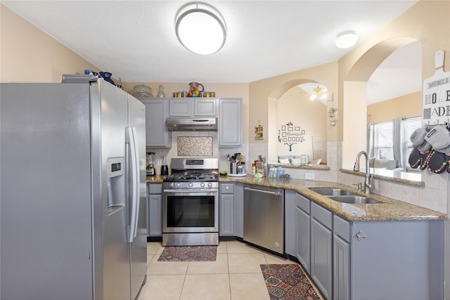 kitchen with gray cabinetry, appliances with stainless steel finishes, sink, and decorative backsplash