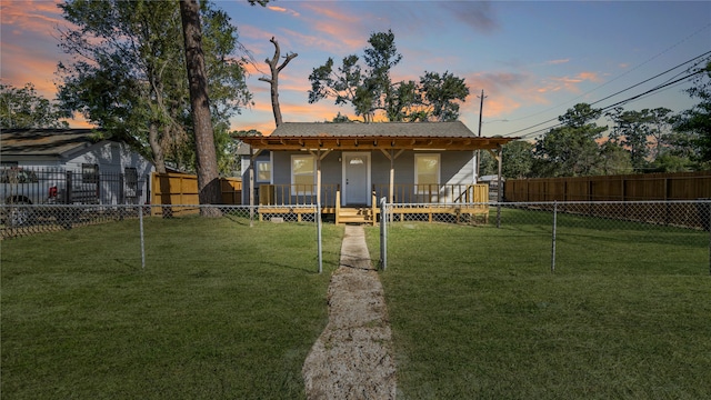 exterior space featuring covered porch, a storage unit, and a yard