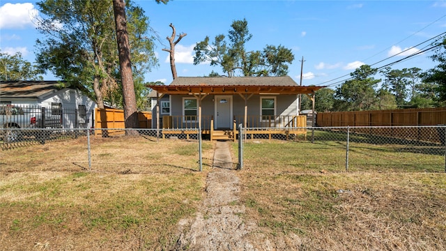 view of front of home with covered porch, a storage unit, and a front lawn