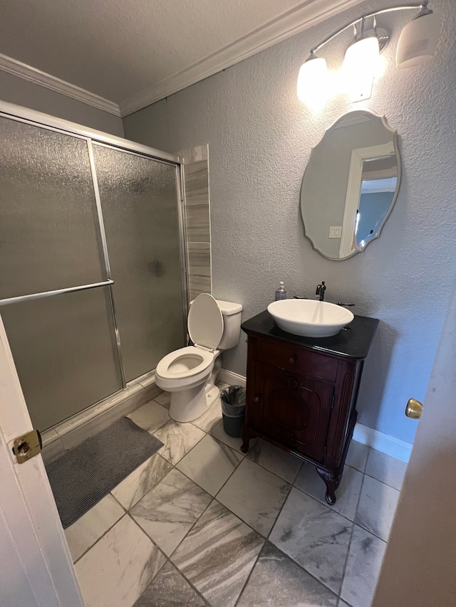 bathroom featuring toilet, a shower with shower door, vanity, and crown molding