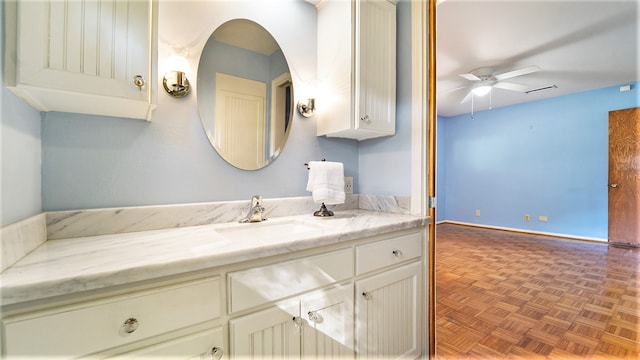 bathroom with parquet flooring, vanity, and ceiling fan