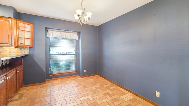 unfurnished dining area featuring light parquet flooring and an inviting chandelier