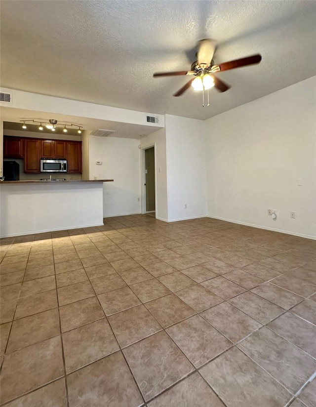 7029 N Holiday Dr, Galveston, TX 77550 - unfurnished living room with light tile patterned flooring, ceiling fan, a textured ceiling, and visible vents