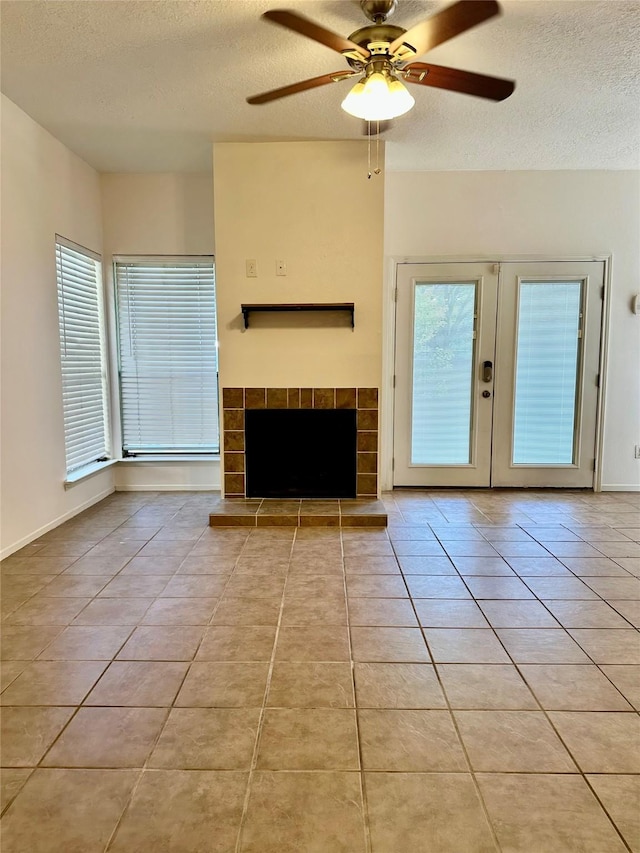 7029 N Holiday Dr, Galveston, TX 77550 - unfurnished living room with light tile patterned flooring, a textured ceiling, ceiling fan, and french doors