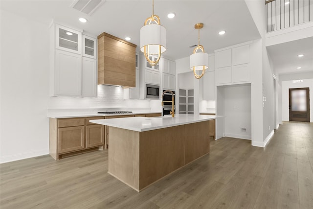 4622 Sycamore Way Rd, Fulshear, TX 77441 - kitchen with stainless steel microwave, light wood-type flooring, light countertops, custom exhaust hood, and recessed lighting