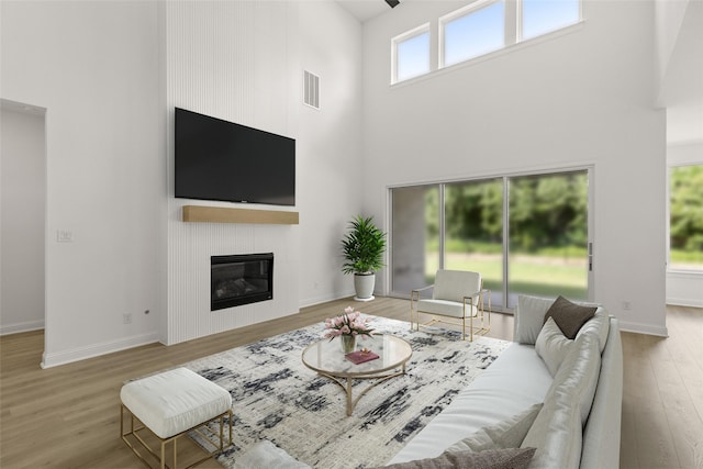 4622 Sycamore Way Rd, Fulshear, TX 77441 - living area featuring a high ceiling, wood finished floors, and a fireplace