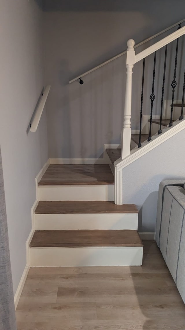 stairs featuring hardwood / wood-style floors